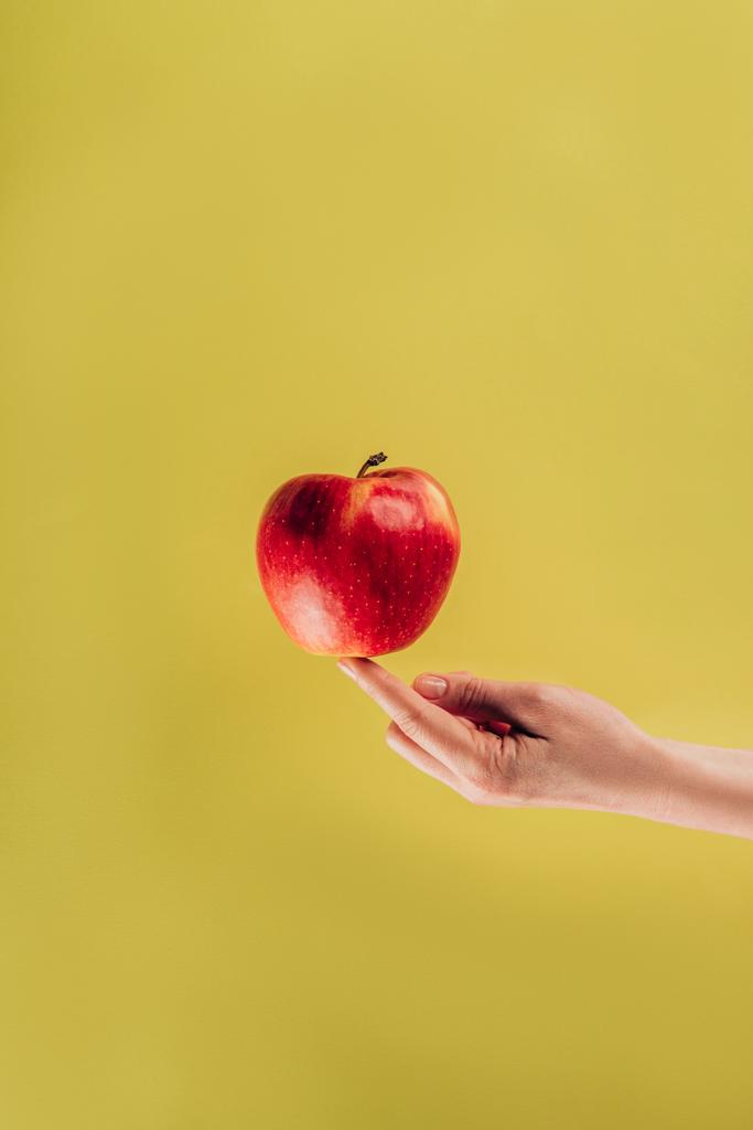 partial view of woman holding apple on finger - Photo, Image