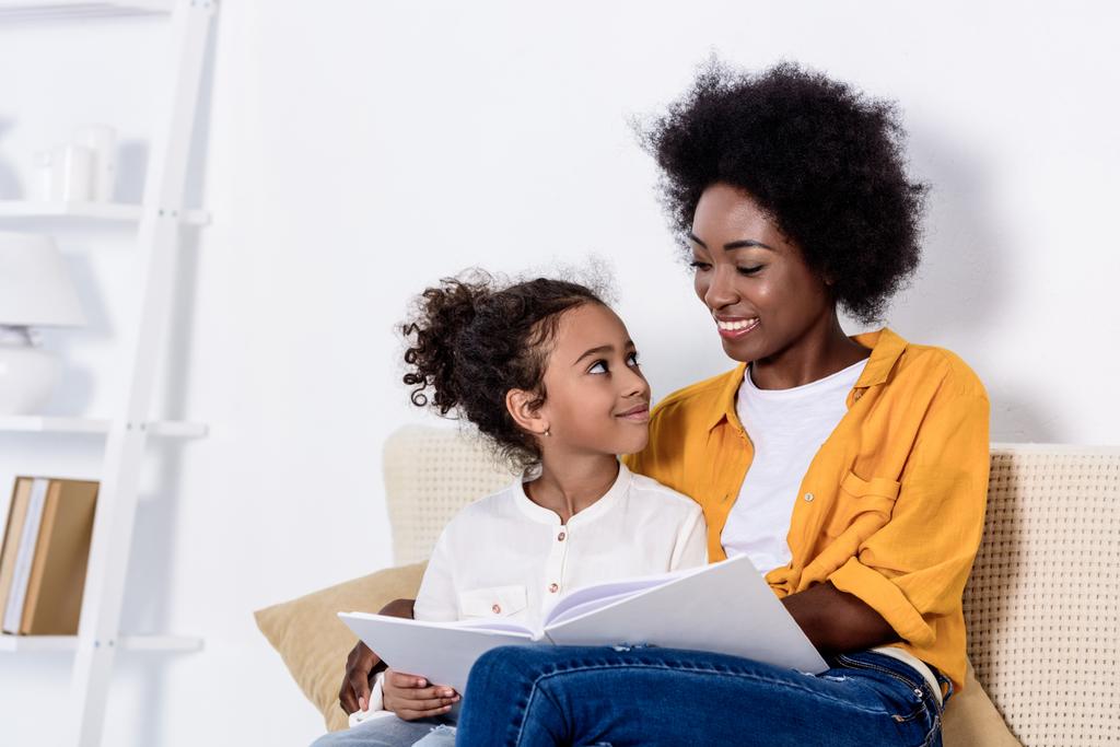 afro americano madre e figlia guardando a vicenda sul divano a casa
 - Foto, immagini
