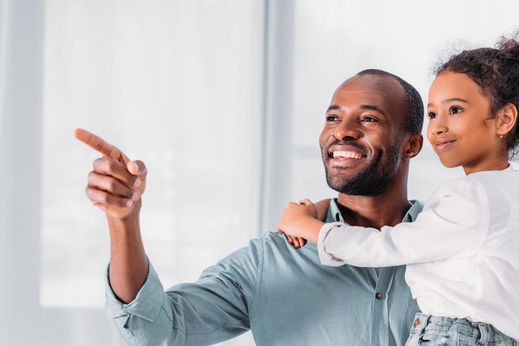 souriant afro-américain père pointant sur quelque chose à fille
 - Photo, image
