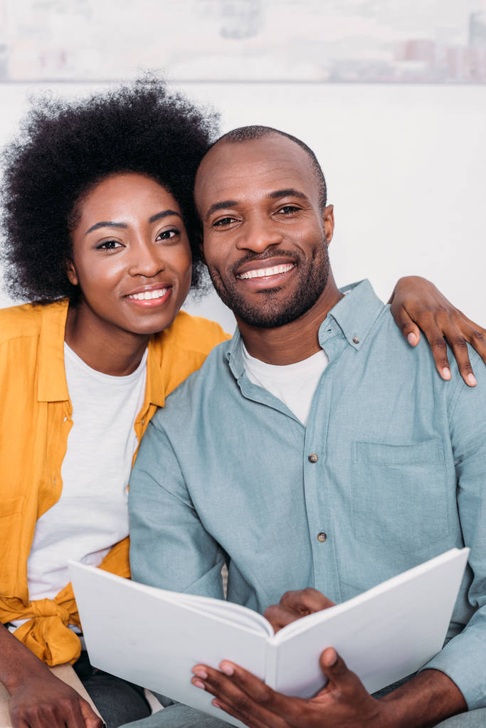 улыбающаяся африканская американская пара обнимается и смотрит в камеру дома
 - Фото, изображение