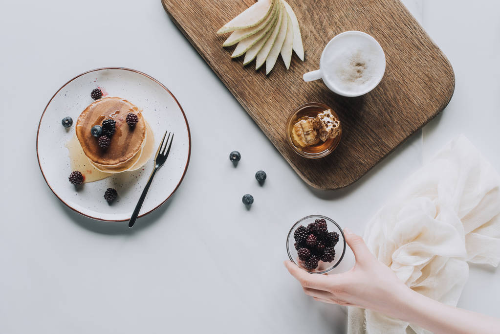 обрізаний знімок людини, що тримає ожину і смачний здоровий сніданок на сірому
 - Фото, зображення