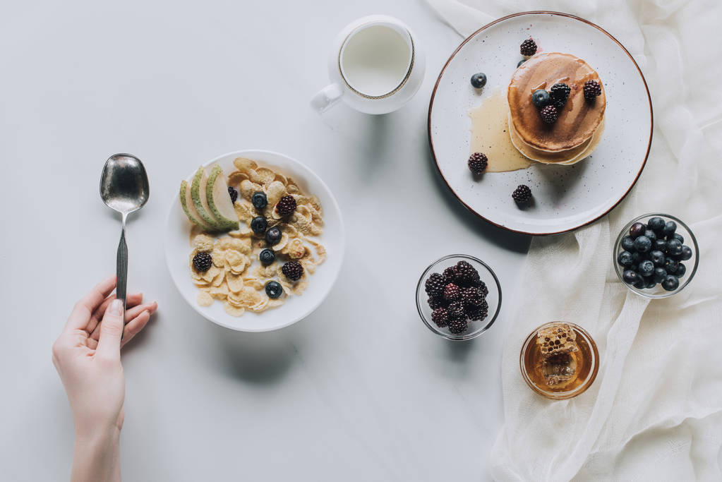 chupito de persona con cuchara y desayuno fresco y saludable en gris
 - Foto, imagen