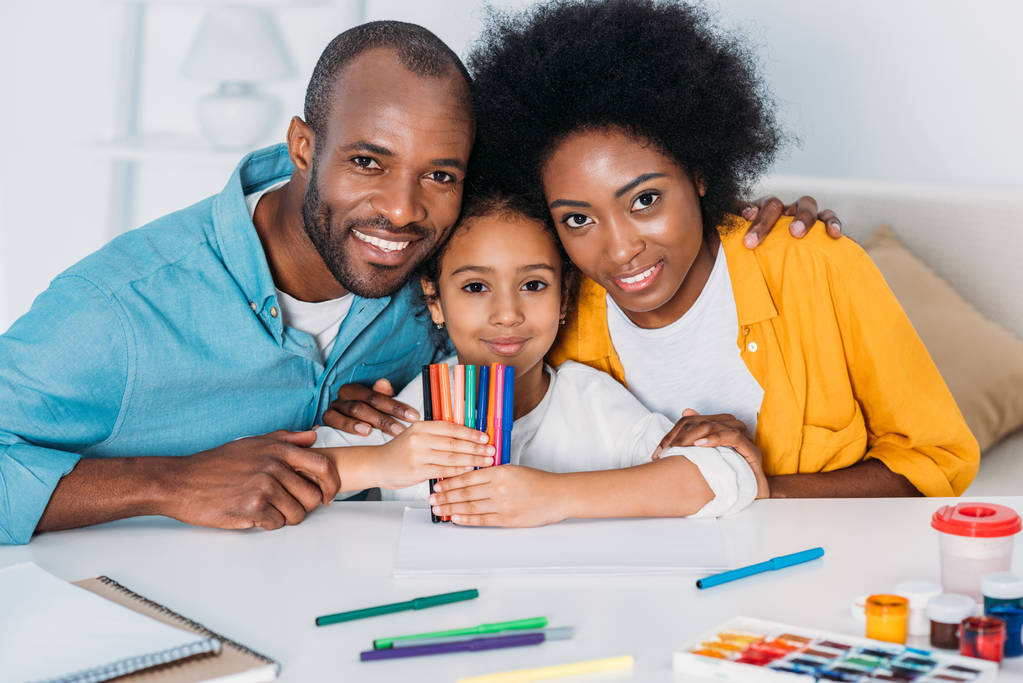 africké americké rodiče a dcera s plstěnou pera při pohledu na fotoaparát doma - Fotografie, Obrázek