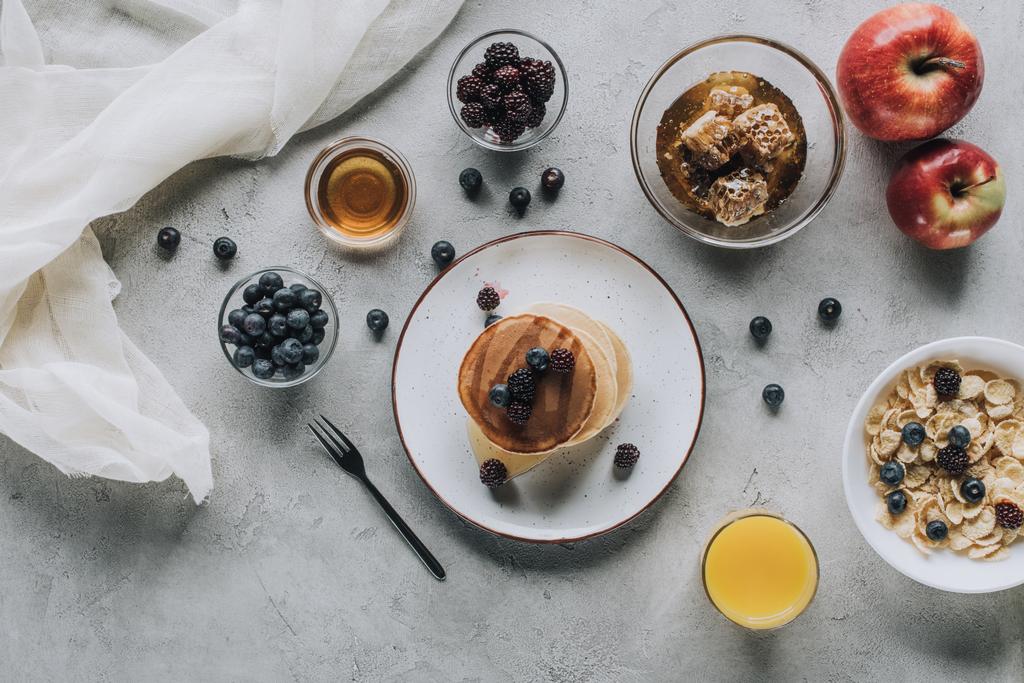 κάτοψη του υγιεινό πρωινό με σπιτικές τηγανίτες, φρέσκα φρούτα και μέλι σε γκρι - Φωτογραφία, εικόνα