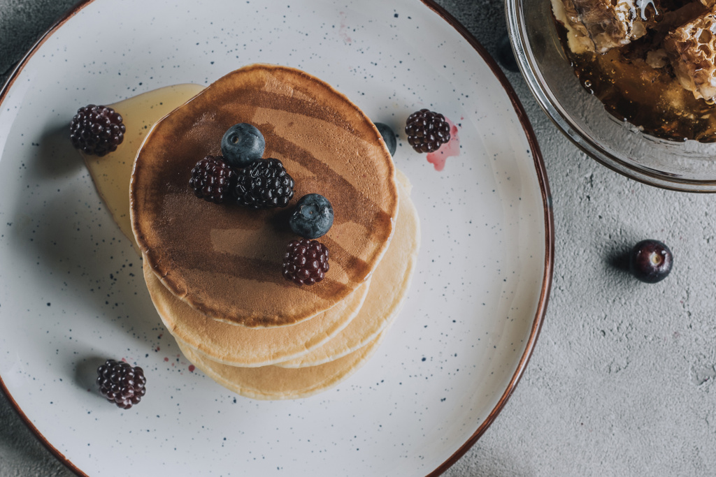 top view of sweet homemade pancakes with fresh berries and honey  - Photo, Image