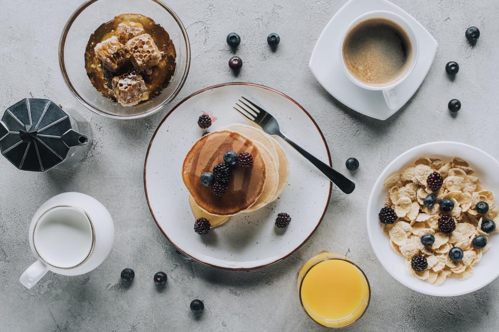 vista dall'alto di gustosa colazione sana con frittelle e muesli su grigio
 - Foto, immagini