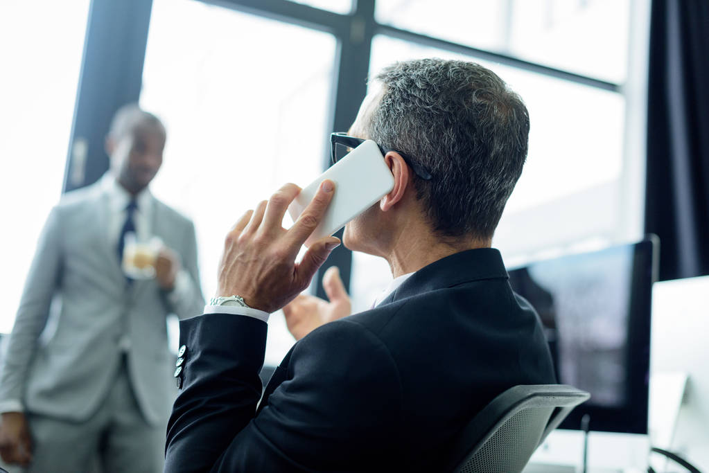 selective focus of businessman talking on smartphone in office - Photo, Image