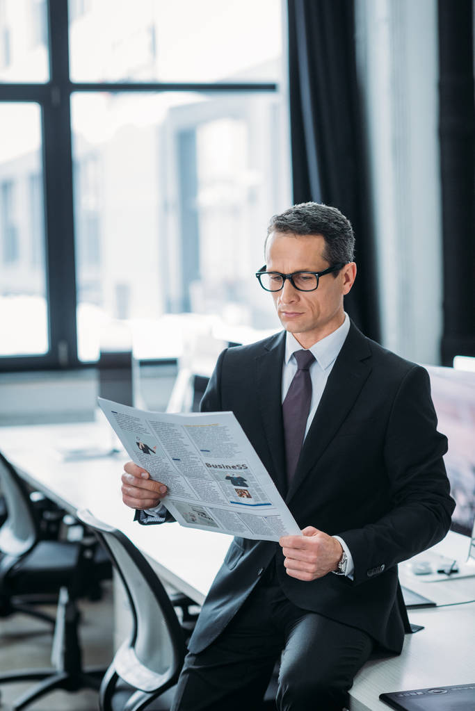πορτρέτο του επικεντρώθηκε επιχειρηματίας διαβάζοντας εφημερίδα στο γραφείο  - Φωτογραφία, εικόνα