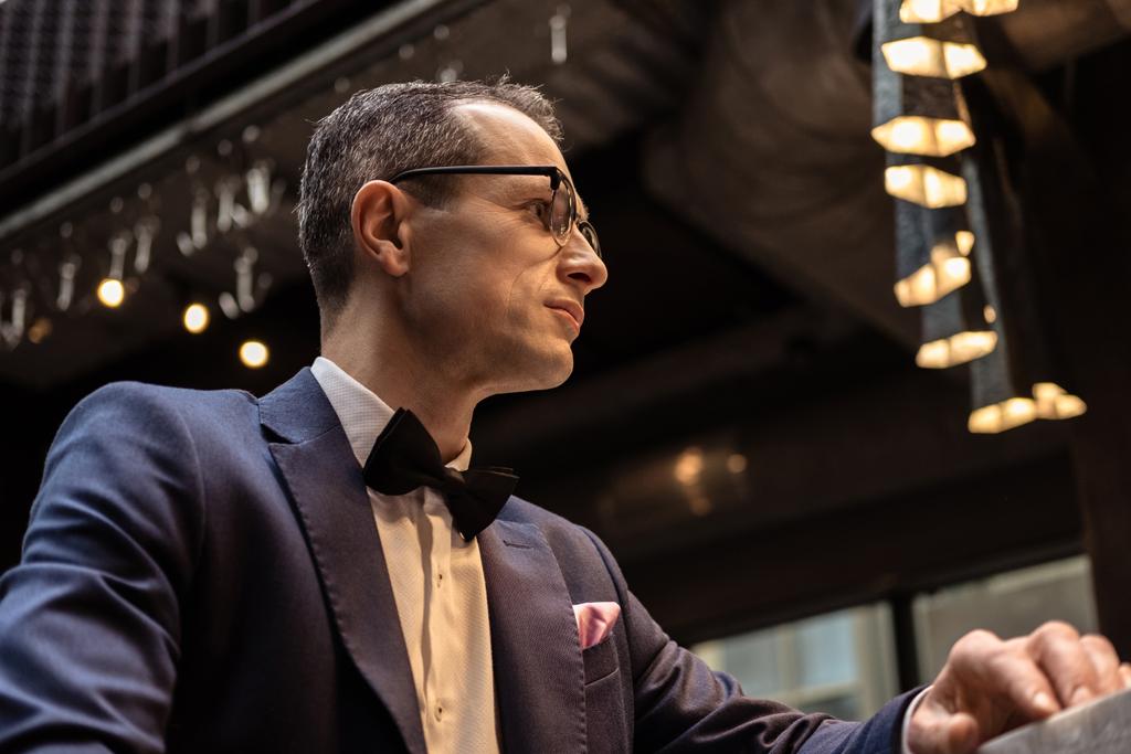 adult man in stylish suit sitting at bar counter and looking away - Photo, Image