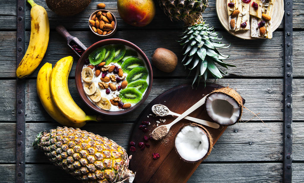 木製の背景にさまざまな果物とヨーグルト。便利な食品、ダイエット、有機. - 写真・画像