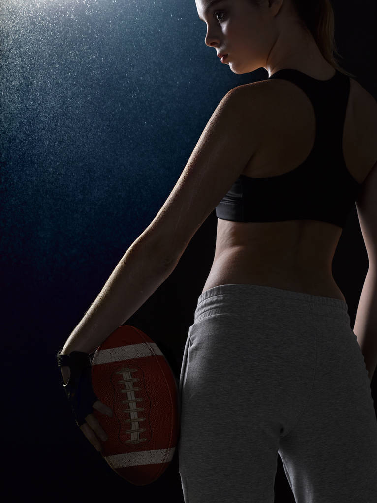 Dívka v obleku sportovní stojí s míčem na americký foo - Fotografie, Obrázek