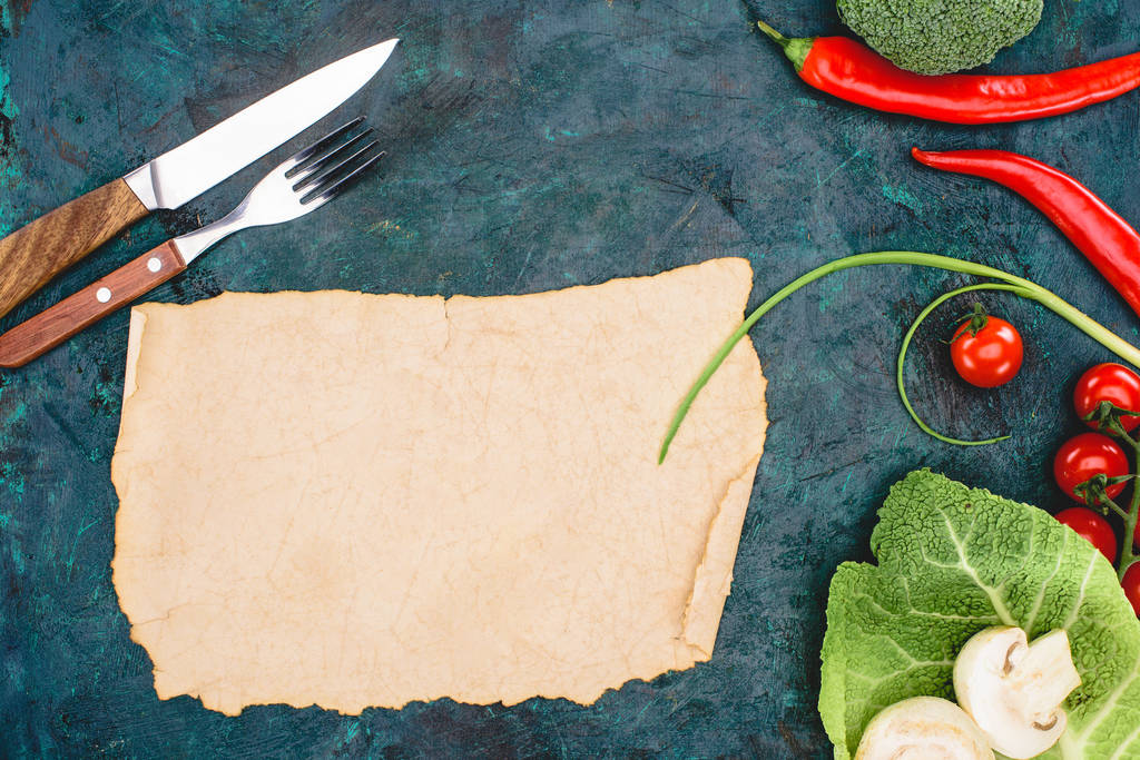 黒の空の羊皮紙、ナイフと熟した生野菜でフォークのトップ ビュー   - 写真・画像