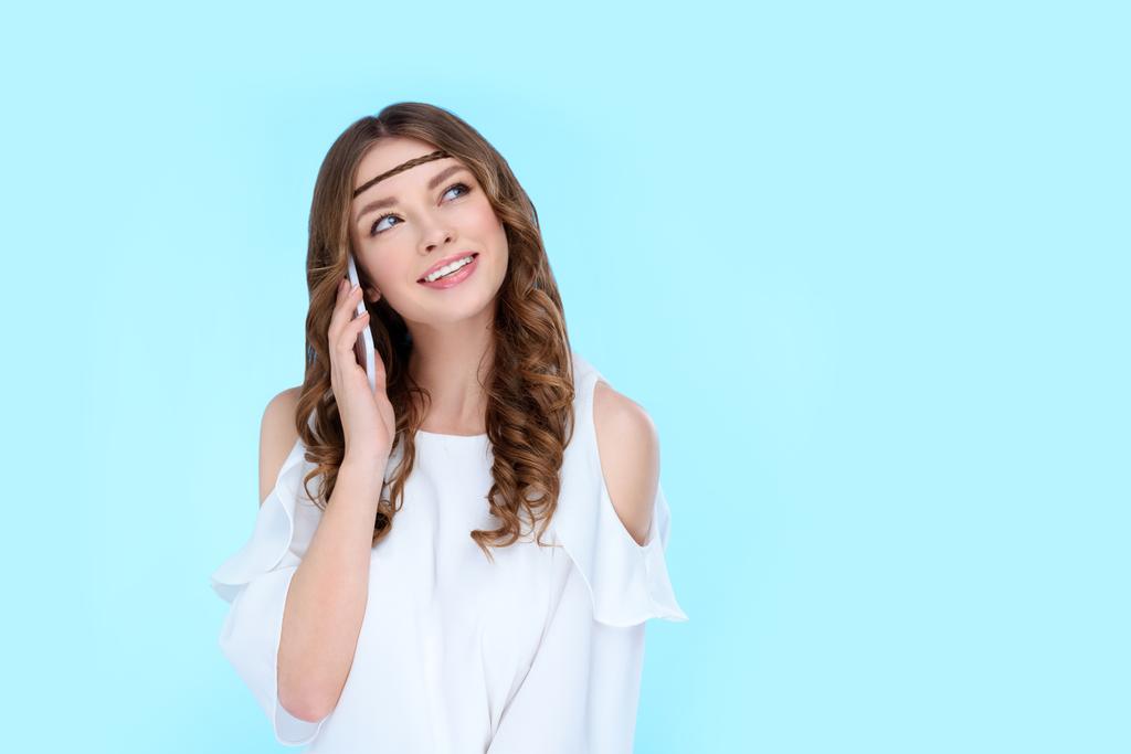 piękna młoda kobieta rozmawia przez telefon na niebieskim tle - Zdjęcie, obraz