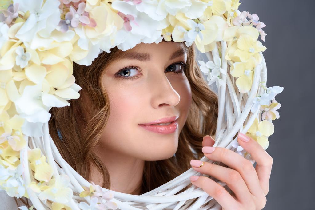 atraente jovem mulher atrás floral grinalda
 - Foto, Imagem