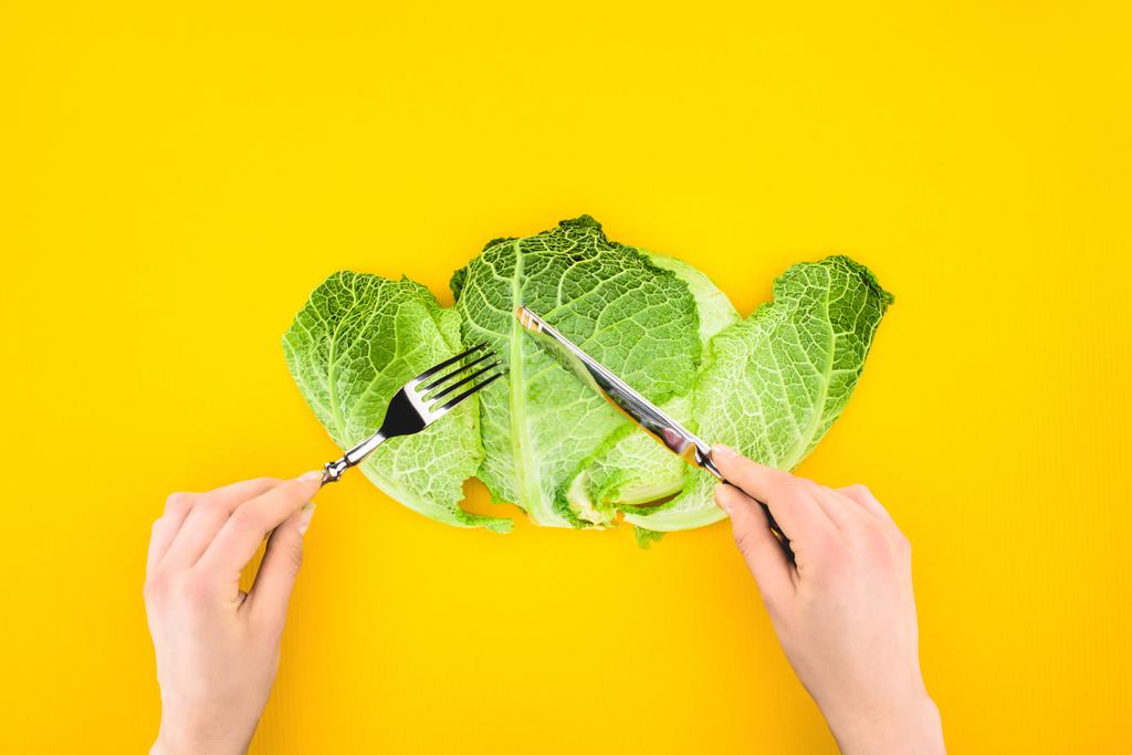 cropped shot of person eating healthy savoy cabbage isolated on yellow - Photo, Image
