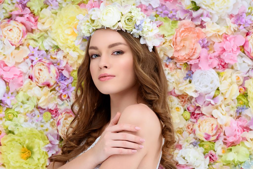 sensuele jongedame in bloemen krans op flral achtergrond - Foto, afbeelding
