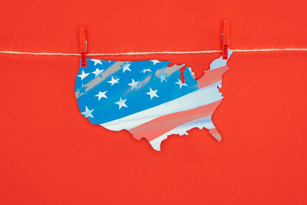 vista superior del pedazo de mapa con la bandera americana colgando en la cuerda aislada en rojo, concepto del día de presidentes
 - Foto, imagen