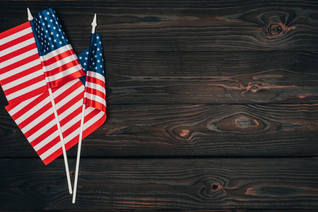 Draufsicht auf arrangierte amerikanische Flaggen auf dunkler Holzoberfläche, Konzept der Präsidententagsfeier - Foto, Bild