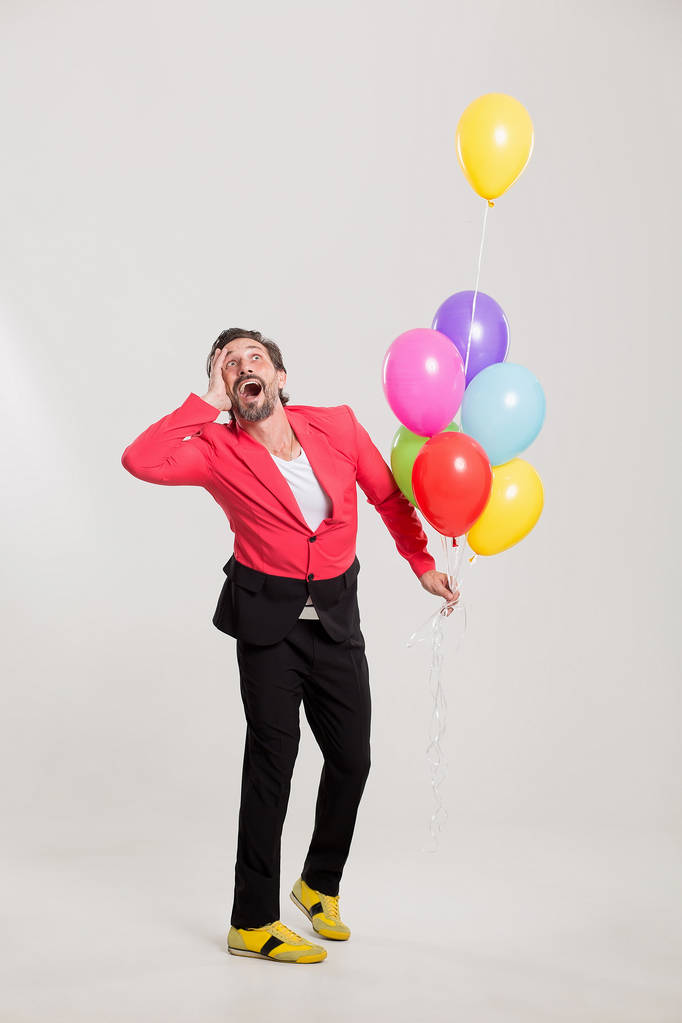 uomo in giacca rossa con palloncini colorati
 - Foto, immagini