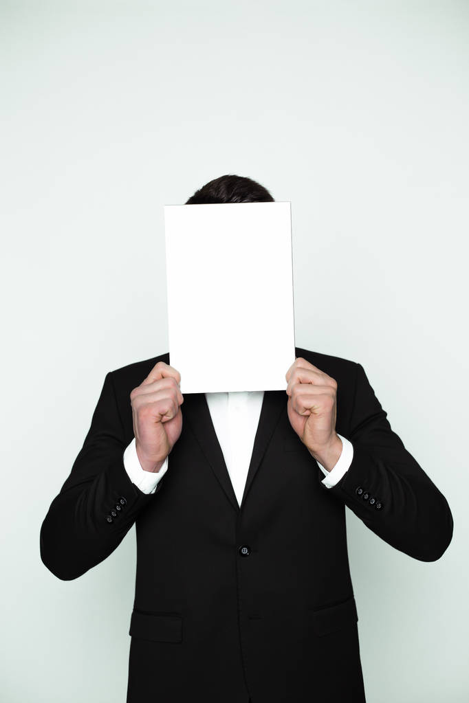 Área em branco para inscrições. Um jovem homem alto cobre seu rosto com uma tábua branca
. - Foto, Imagem