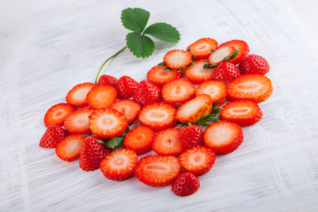 fraises fraîches mûres en forme de coeur sur la table de cuisine plaque de bois blanc peut être utilisé comme fond
 - Photo, image