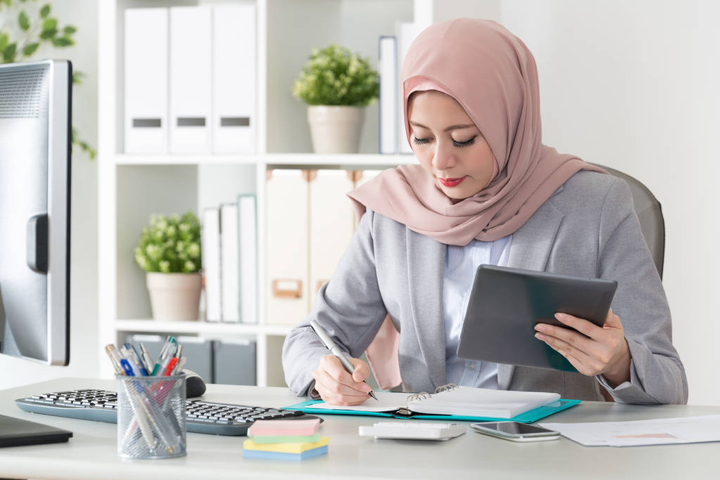 donna d'affari musulmana che utilizza il lavoro del computer mobile
 - Foto, immagini