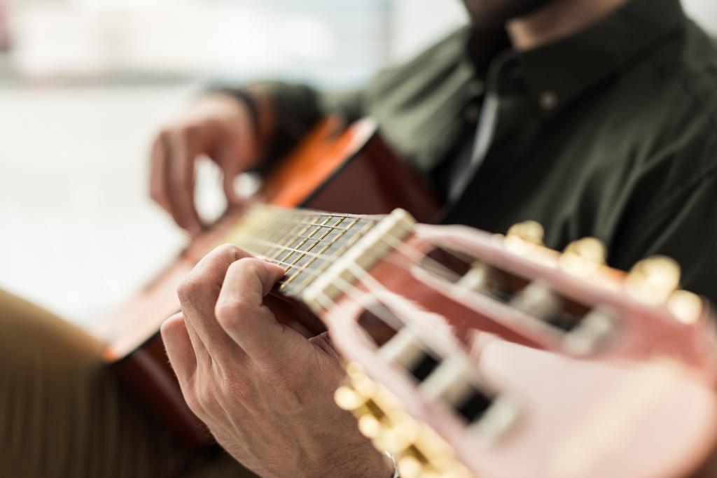 bijgesneden afbeelding van muzikant akoestische gitaar spelen - Foto, afbeelding