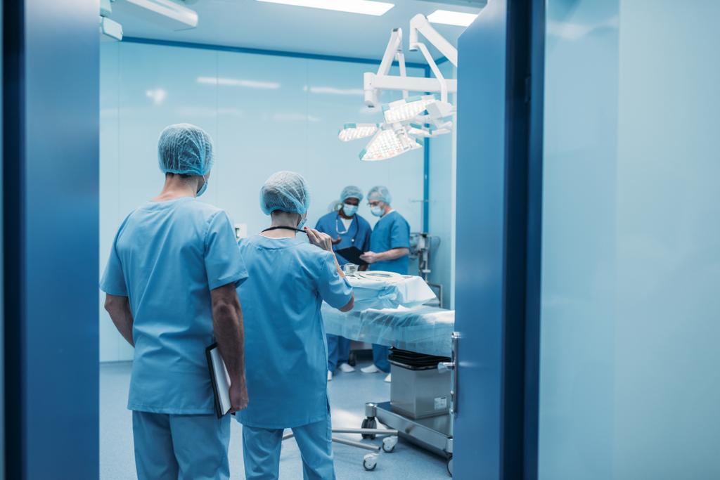 Rückansicht multikultureller Chirurgen im Operationssaal - Foto, Bild