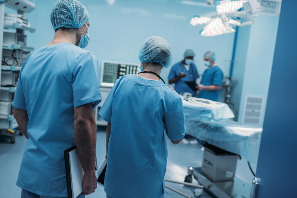 cuatro cirujanos multiétnicos en quirófano
 - Foto, Imagen