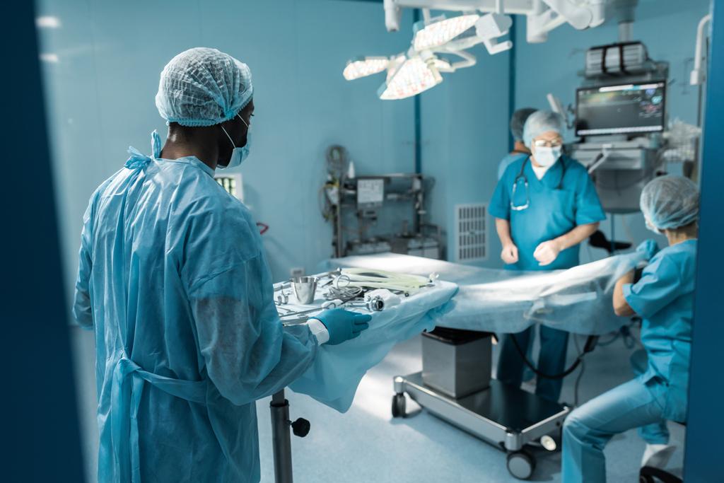 médecin afro-américain tenant plateau avec des outils médicaux pour la chirurgie
 - Photo, image