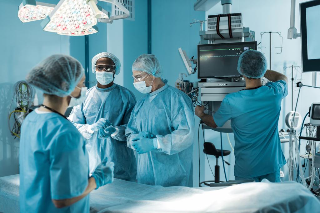 neljä monikulttuurista lääkäriä valmistautumassa leikkaukseen
 - Valokuva, kuva