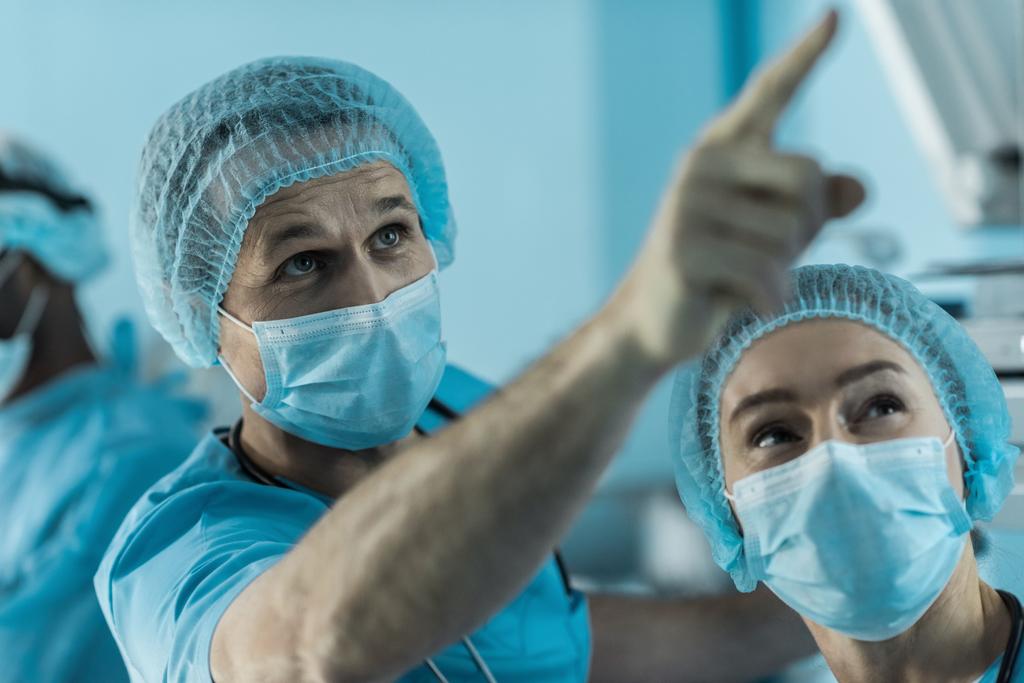 ο γιατρός δείχνει πάνω σε κάτι στο χειρουργείο - Φωτογραφία, εικόνα