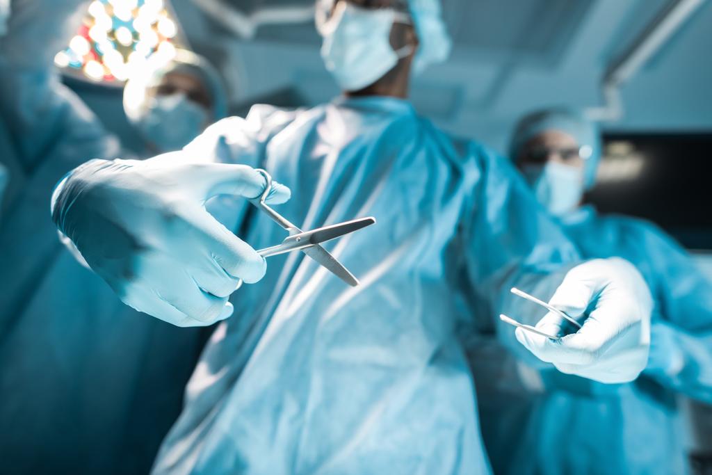visão inferior de cirurgiões multiculturais com ferramentas médicas
 - Foto, Imagem
