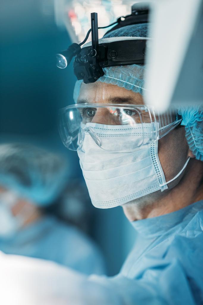 cirurgião bonito em máscara médica olhando para longe
 - Foto, Imagem