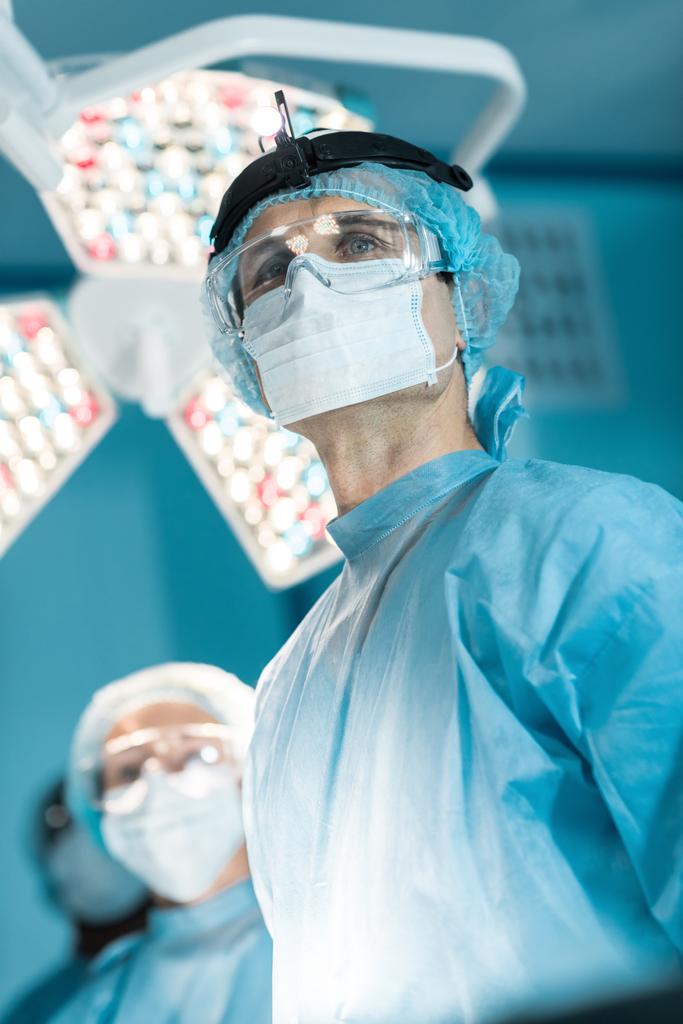 tıbbi maskesi uzağa bakarak cerrah alttan görünüm - Fotoğraf, Görsel