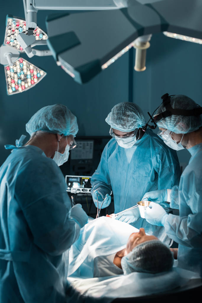 chirurgiens multiethniques opérant patient en salle d'opération
 - Photo, image