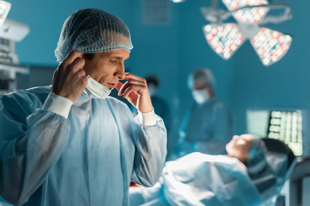 chirurg dragen van medische masker in operatiekamer - Foto, afbeelding