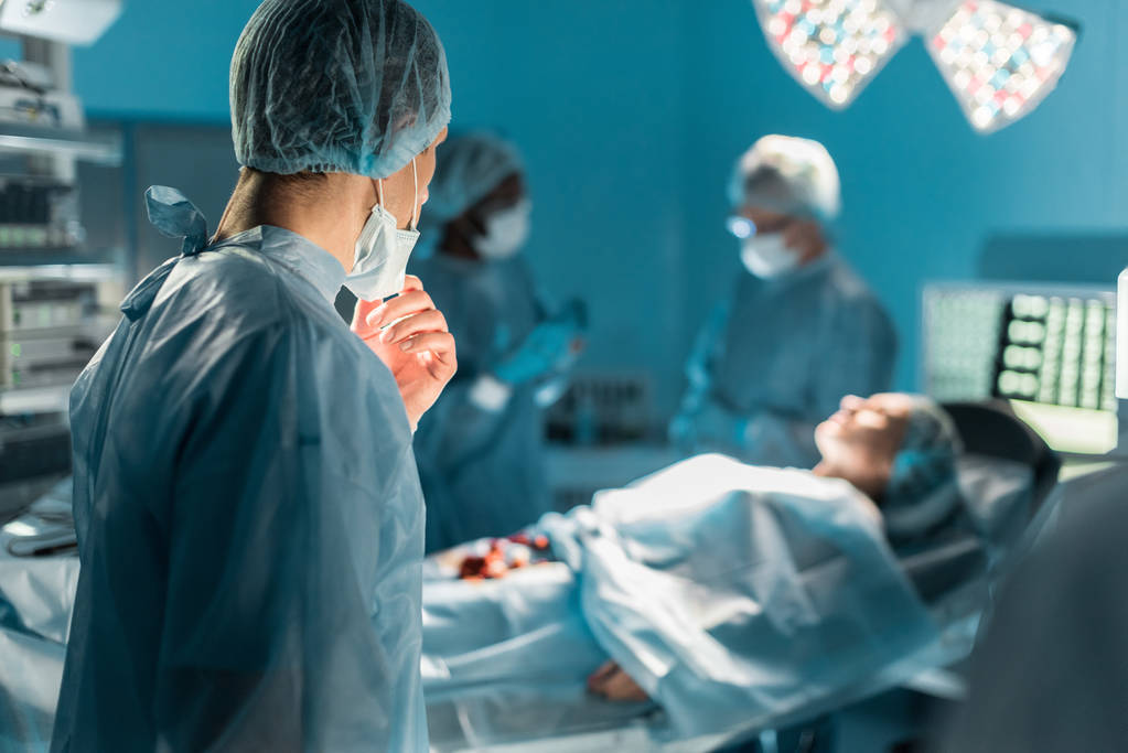 multiculturele chirurgen en vrouwelijke patiënt in operatiekamer - Foto, afbeelding