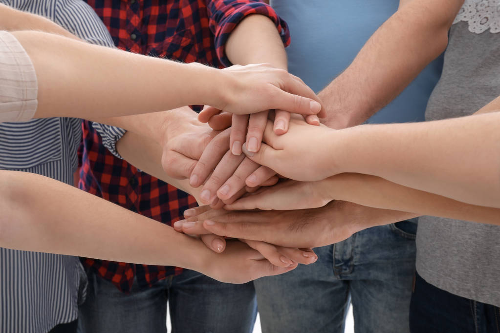 Mladí lidé uvedení ruce dohromady jako symbol jednoty, closeup - Fotografie, Obrázek