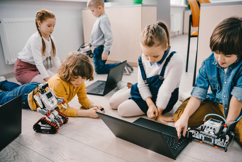 діти програмують роботів з ноутбуками, сидячи на підлозі, концепція освіти стовбурів
 - Фото, зображення