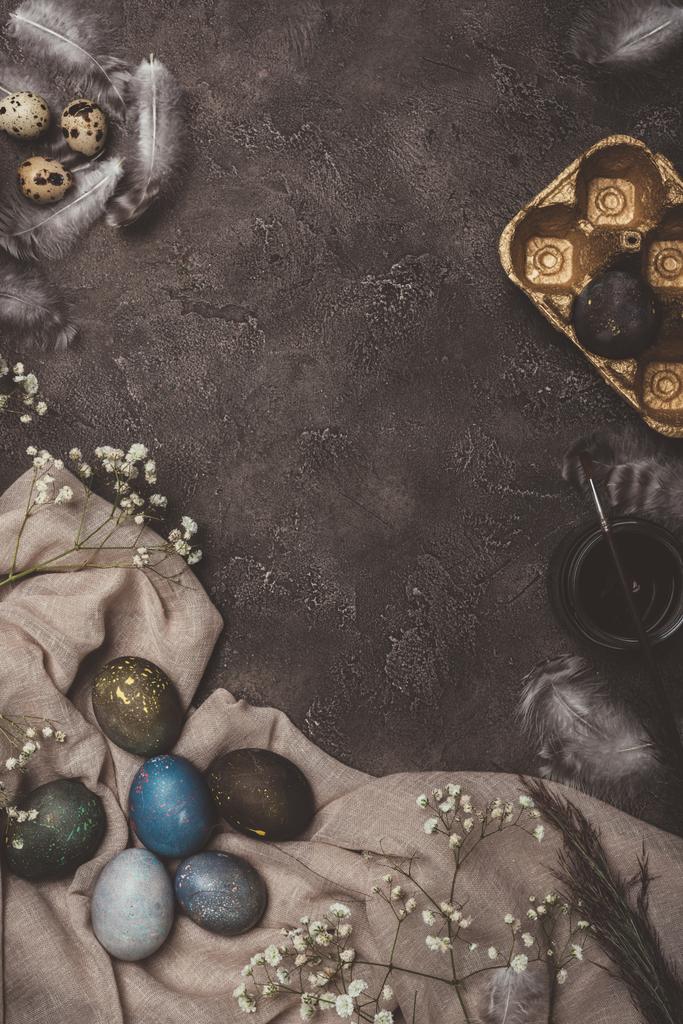 vista superior de huevos de Pascua, bandeja dorada, flores, pintura y pincel sobre tela
 - Foto, Imagen