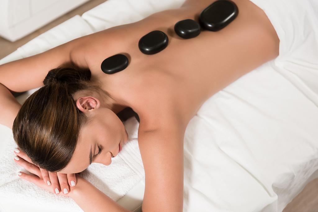 bela jovem mulher tendo pedras quentes massagem no salão de spa
 - Foto, Imagem