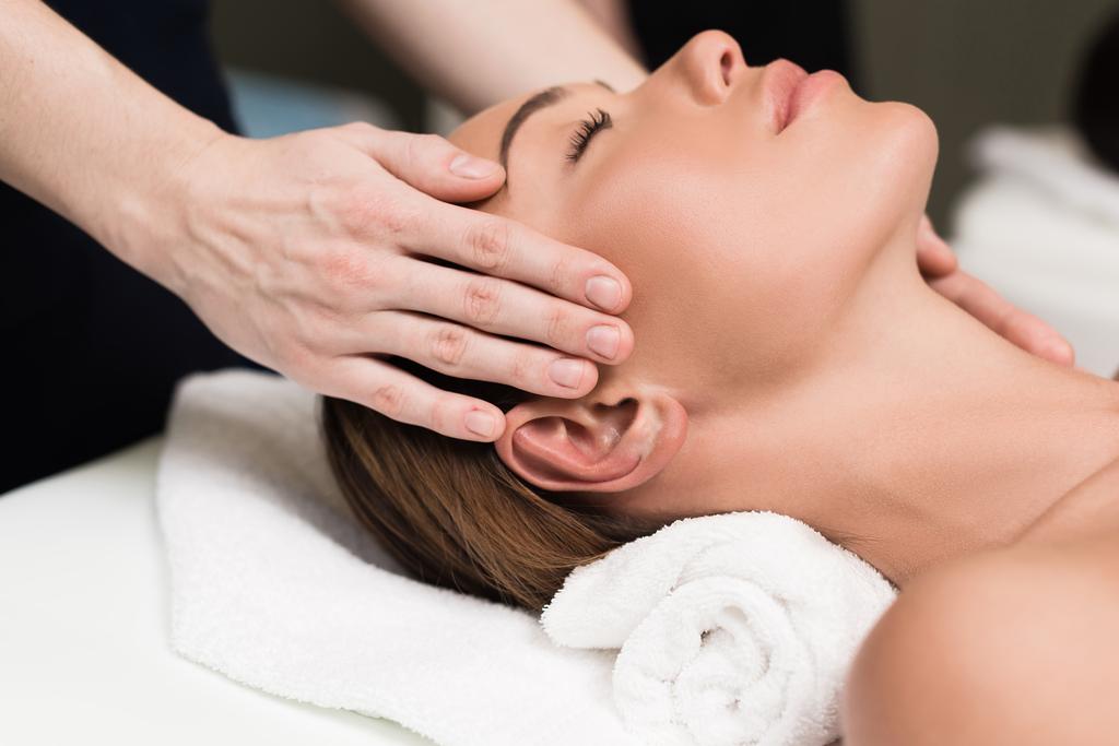 jeune femme relaxant et ayant massage de la tête dans le salon de spa
 - Photo, image