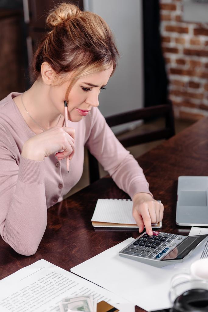 vista lateral de la mujer haciendo cálculos en la mesa en casa, concepto de problemas financieros
 - Foto, Imagen