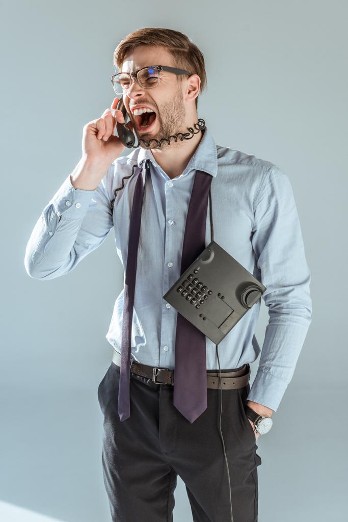 Nuori harmitti liikemies huutaa puhuessaan puhelimessa
 - Valokuva, kuva