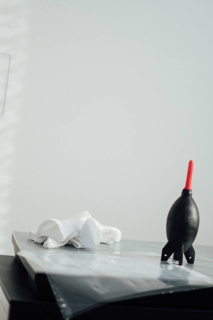 Dark table with toy bomb at towel over white wall - Photo, Image