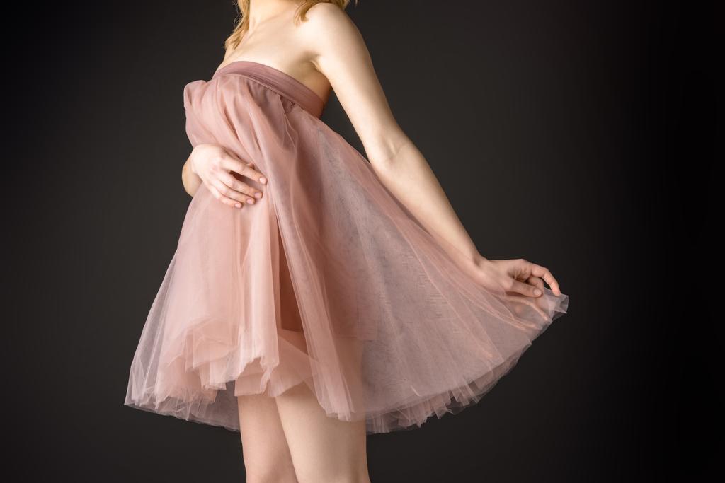 midsection näkymä tarjouksen tyttö poseeraa vaaleanpunainen sifonki mekko, eristetty harmaa
 - Valokuva, kuva