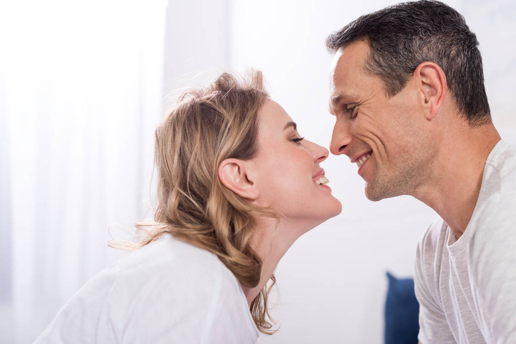 side view of happy couple in love looking at each other at home - Photo, Image