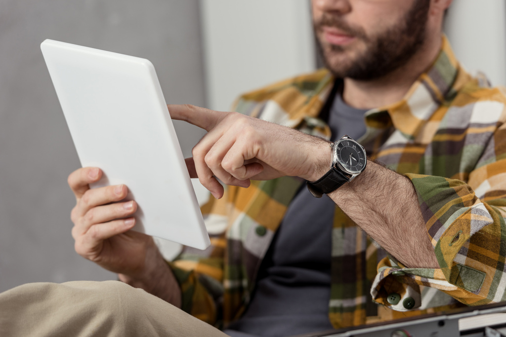 cropped image of man using digital tablet while sitting  - Photo, Image