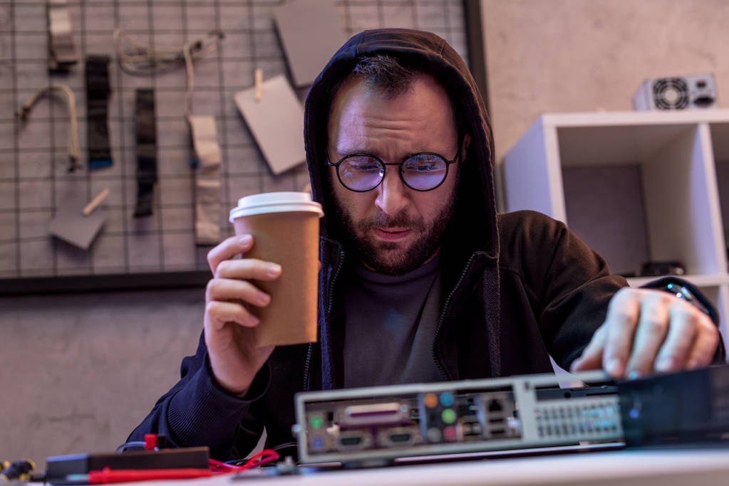 человек с кофе в руке смотрит на сломанный компьютер
 - Фото, изображение